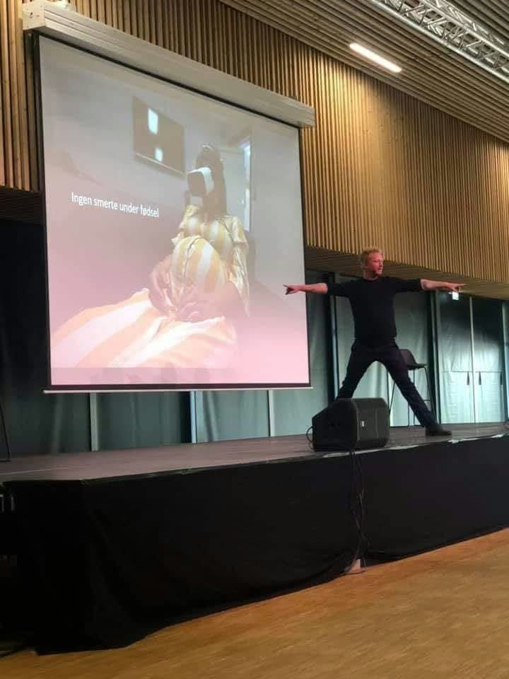 Jesper Roy Nørklit på scenen med en VR-præsentation