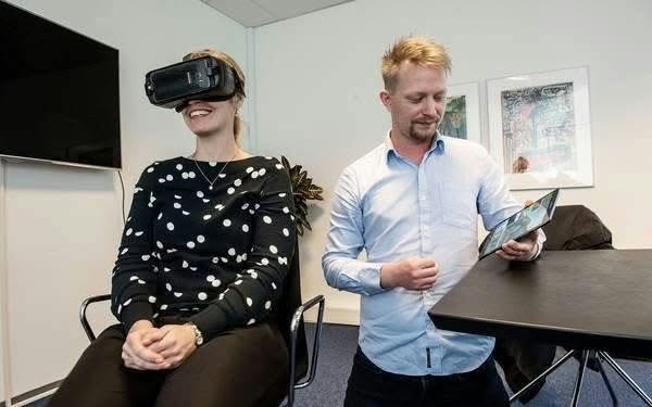 Jesper Roy Nørklit demonstrerer VR med en tablet, mens en deltager bærer VR-briller